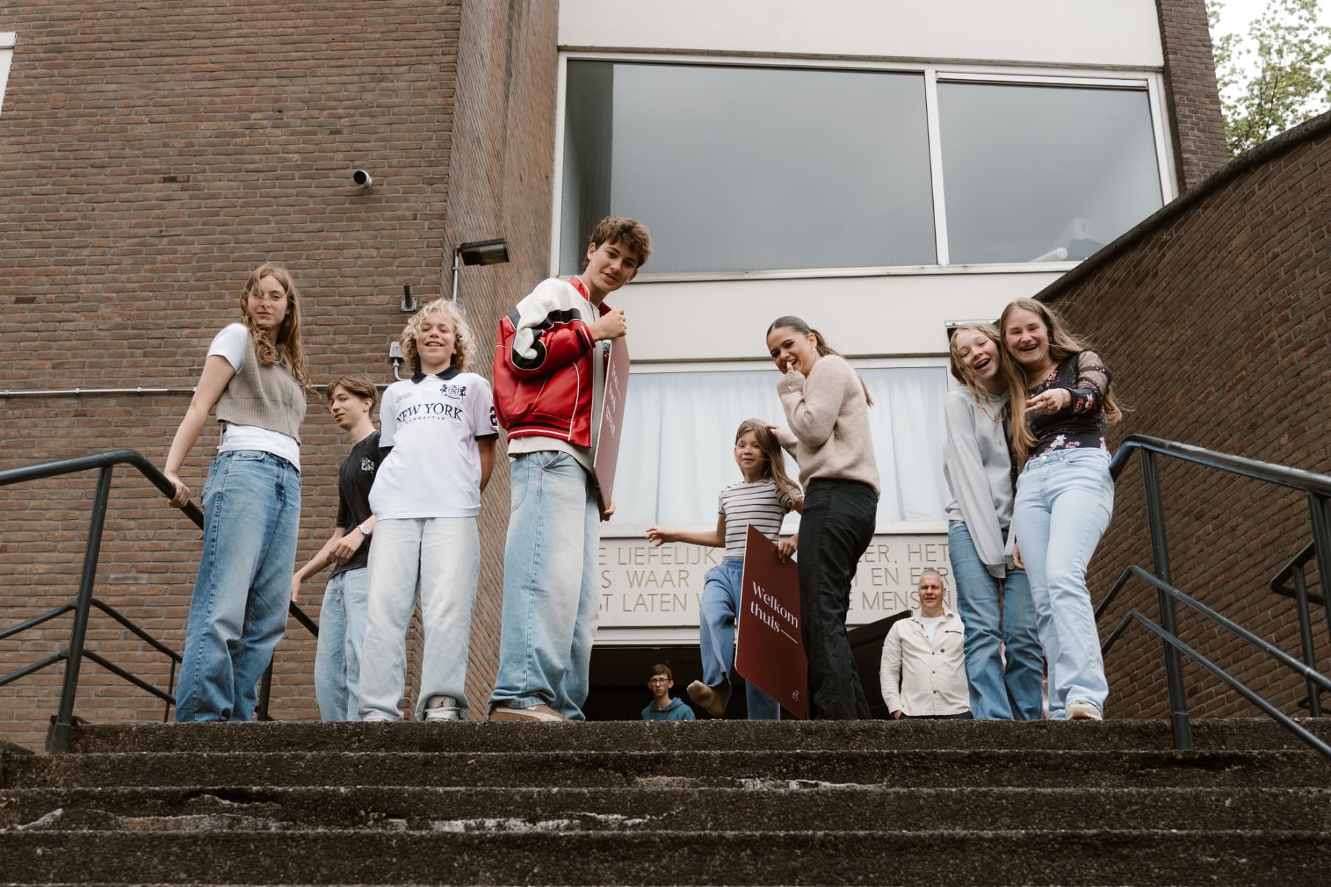 Groep jongeren lachend op de trap bij de kerk
