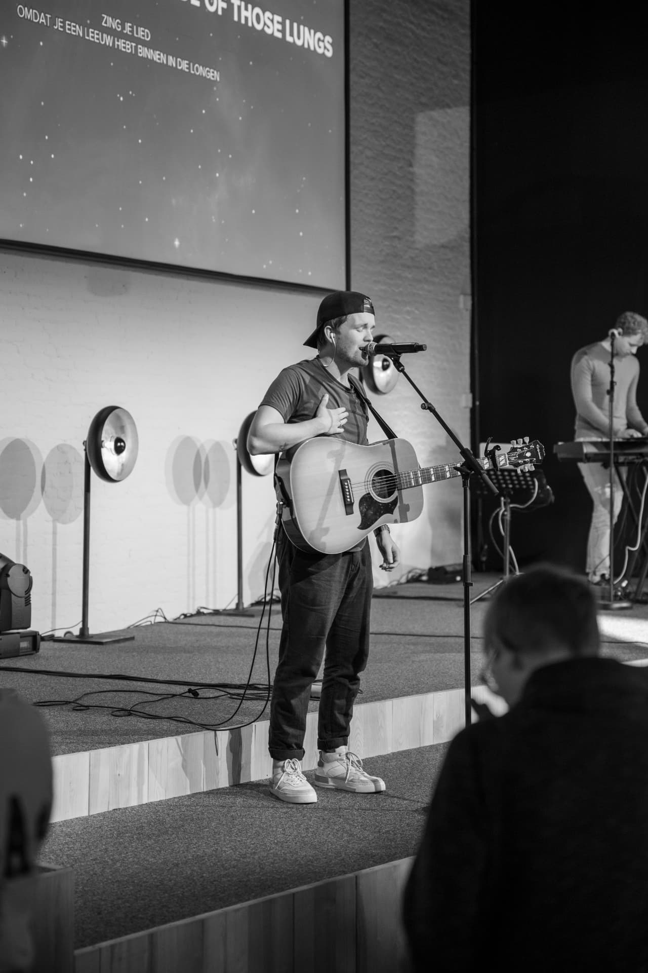 Worshipleider met gitaar tijdens de aanbidding