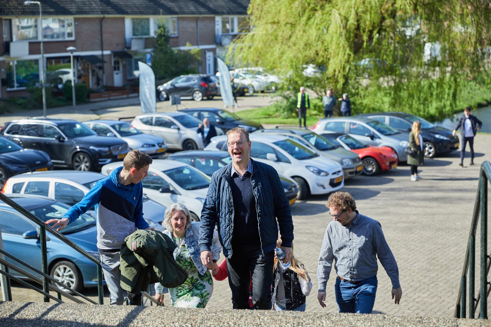 Bezoekers lopen lachend de trap op naar de kerk