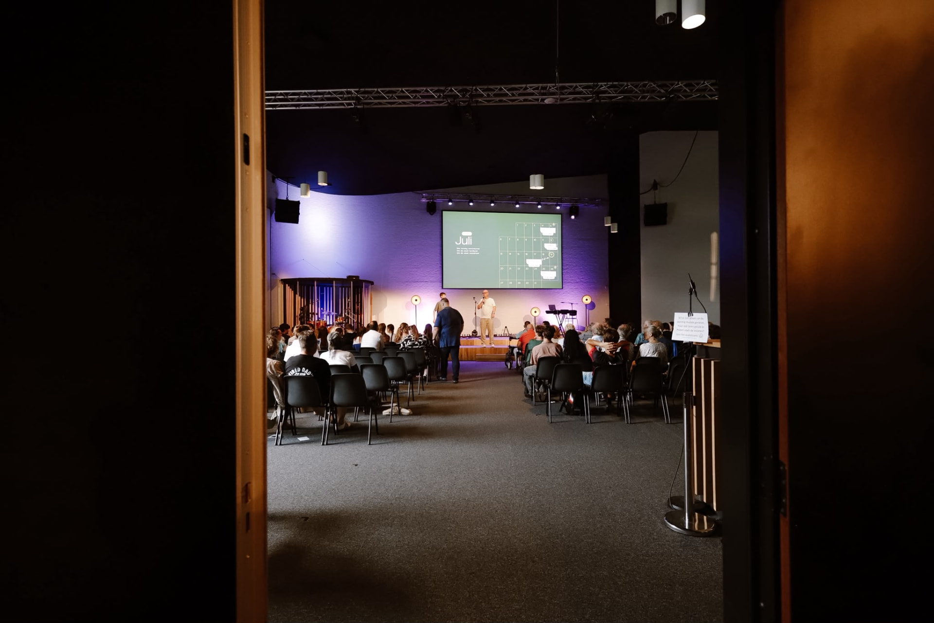 Blik door de deuren op de kerkzaal tijdens de dienst